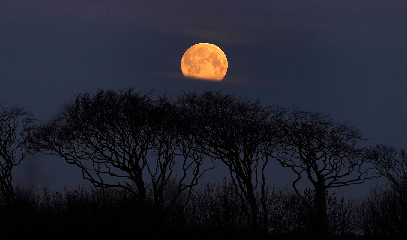 Une pleine lune se couche prÃ¨s de Whitley Bay (Grande-Bretagne) alors que le soleil commence Ã  se lever. 