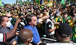 TOPSHOT - Brazilian President Jair Bolsonaro greets supporters during a demonstration in Brasilia, on May 31, 2020 during the COVID-19 novel coronavirus pandemic. - Bolsonaro, who fears the economic fallout from stay-at-home orders will be worse than the virus, has berated governors and mayors for imposing what he calls "the tyranny of total quarantine." Even as his country surpassed France to have the world's fourth-highest death toll, Bolsonaro called for Brazil's football season to resume. (Photo by EVARISTO SA / AFP)