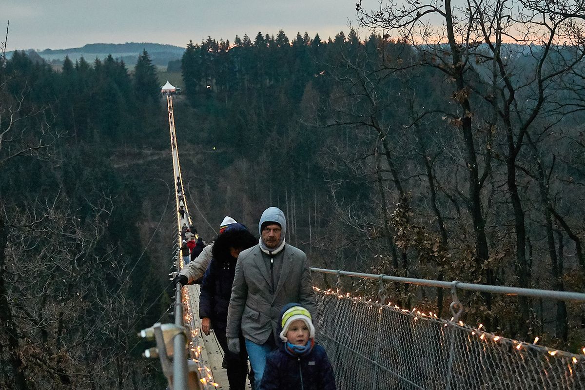 Besucher gehen während der Veranstaltung "Geierlights" über die Hängeseilbrücke Geierlay. 