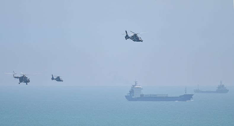 TOPSHOT - Chinese military helicopters fly past Pingtan island, one of mainland China's closest point from Taiwan, in Fujian province on August 4, 2022, ahead of massive military drills off Taiwan following US House Speaker Nancy Pelosi's visit to the self-ruled island. - China is due on August 4 to kick off its largest-ever military exercises encircling Taiwan, in a show of force straddling vital international shipping lanes following a visit to the self-ruled island by US House Speaker Nancy Pelosi. (Photo by Hector RETAMAL / AFP)