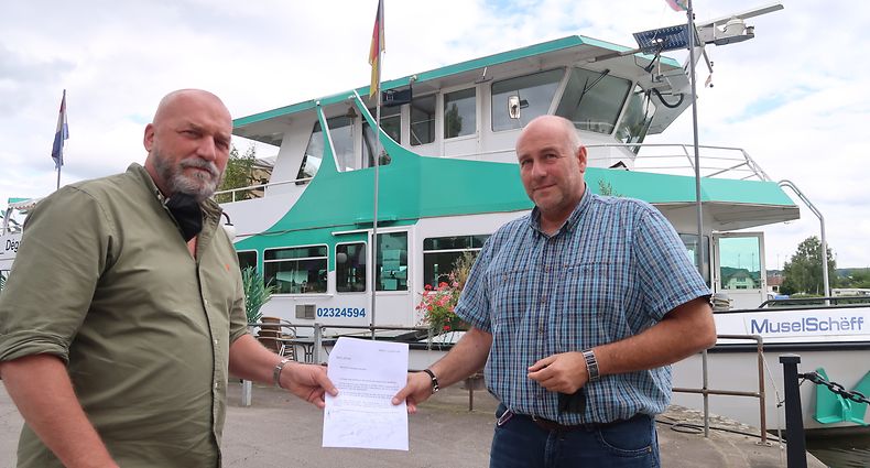Daniel Frères (links), Vizepräsident des Remicher Geschäftsverbandes, nimmt die Petition mit zwei Dutzend Unterschriften von Navitours-Geschäftsführer Daniel Kieffer entgegen.